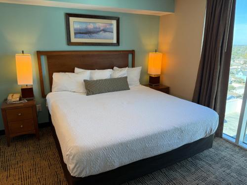 a bedroom with a bed with two lamps and a window at Towers at North Myrtle Beach in Myrtle Beach