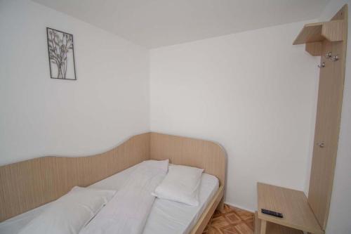 a bed in a room with a white wall at La David Straja in Straja