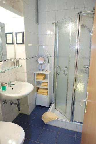 a bathroom with a shower and a sink at Hotel Mellum in Wangerland