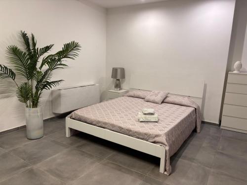 a bedroom with a bed and a potted plant at Home Sicilia in Carini