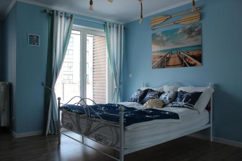 a bedroom with a bed with blue walls and a window at U Rudobrodego in Pogórze
