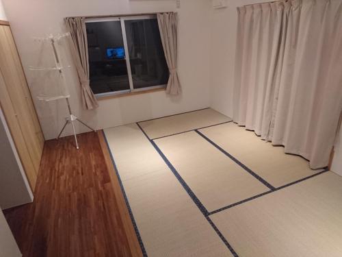 a small room with white floors and a window at Kaeruya in Nakijin