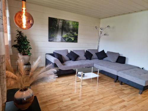 a living room with a blue couch and a table at Bachoase Bischofsmais in Bischofsmais