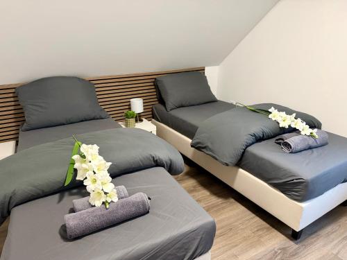 two beds with flowers on them in a room at Apartment Mira 13 in Pulheim