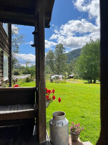 ein Blick auf einen Hof von einer Veranda mit Blumen in der Unterkunft Sevletunet B&B and Cabins in Rødberg