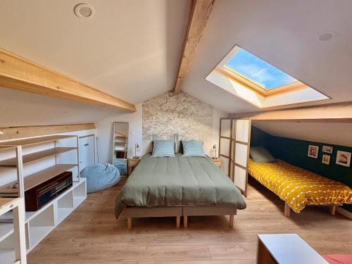 a bedroom with a large bed and a skylight at Bel-Air des Collines in Saint-Martin-dʼAoût