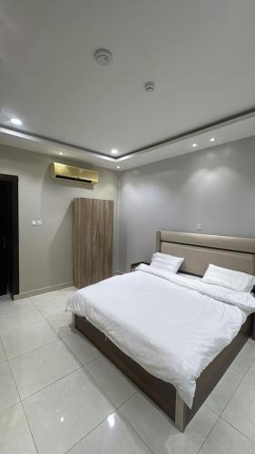 a bedroom with a large bed with white sheets at شاليهات تولين 2 in Taif