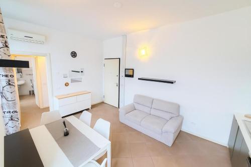 a white living room with a white couch and a table at Moderno appartamento a 2 passi dal centro in Brescia