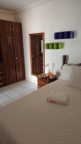 a bedroom with a large bed with a wooden cabinet at Casa Meão in Recife
