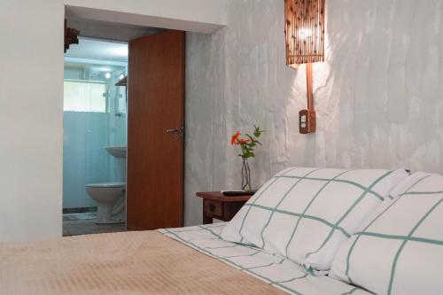 a bedroom with a bed and a bathroom with a toilet at Ecofazenda Lodge in Bofete