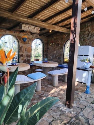 a room with tables and benches in a stone building at Quinta do Paraiso in São Teotónio