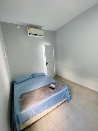 a bedroom with a blue bed in a white room at -TROPICAL SUÍTES- ao lado do SESC-BERTIOGA in Bertioga