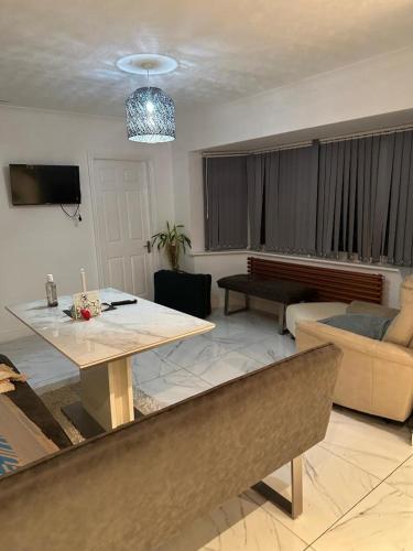 a living room with a table and a couch at Stillwater Cabin Suite in Glascote