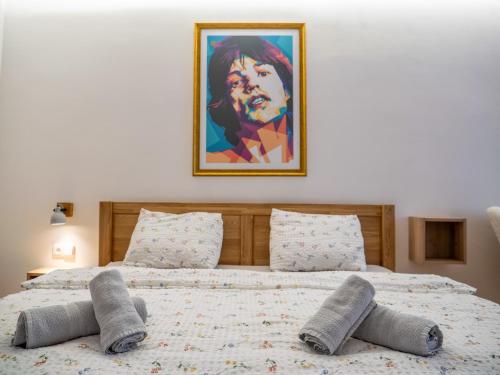 two beds in a bedroom with a painting on the wall at Apartmán Mick Jagger in Nymburk