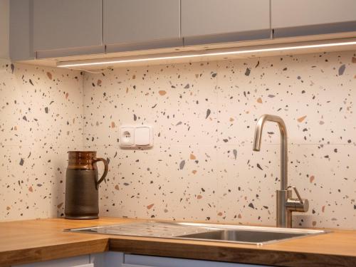 a kitchen with a sink and a wallpaper with flowers at Apartmán Ve středu dění in Poděbrady
