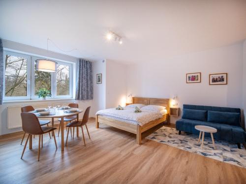 a bedroom with a bed and a table and a blue couch at Apartmán Ve středu dění in Poděbrady