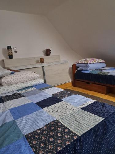 a bedroom with two beds and a dresser at Domacinstvo Majovac in Drenova