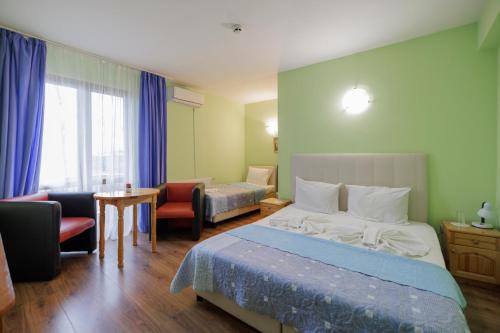 ein Hotelzimmer mit Bett, Tisch und Stühlen in der Unterkunft Trafi Em in Sofia
