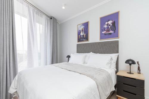 a bedroom with a white bed and a window at Elegant AirConditioned Neria at Ellipse Waterfall in Midrand