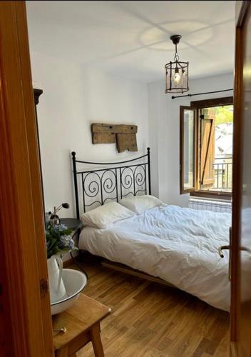 a bedroom with a bed and a table and a sink at Chalet Hoz de Jaca in Hoz de Jaca
