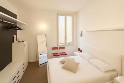 a white bedroom with a white bed and a mirror at Moderno appartamento a 2 passi dal centro in Brescia