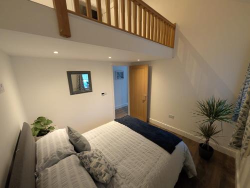 a bedroom with a large bed and a staircase at Allensmore House Gower in Swansea