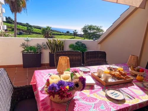 a table with a pink table cloth with food on it at NEW Duplex Penthouse, Spectacular Ocean View in Manilva