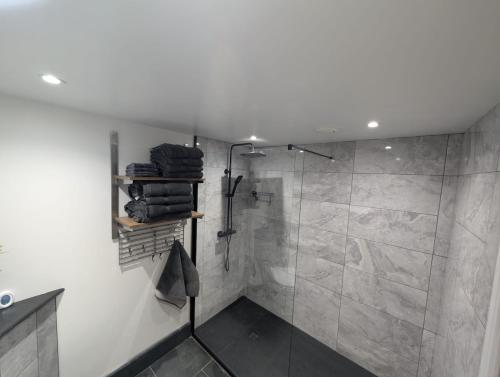 a bathroom with a shower with a tiled shower at Allensmore House Gower in Swansea