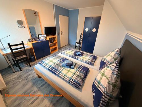 a bedroom with a bed with pillows and a desk at Pension & Gästehaus Legden in Legden