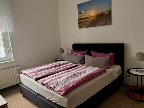 a bedroom with a bed with a pink comforter at Ferienwohnung Poschmann in Bad Wilsnack