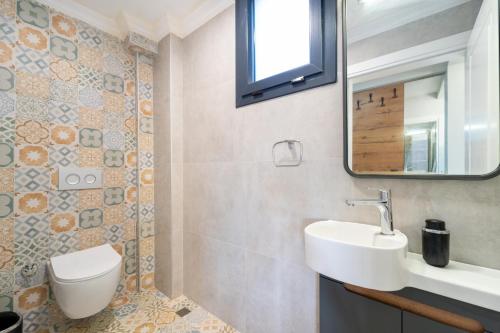 a bathroom with a sink and a toilet and a mirror at Villa Aden in Fethiye