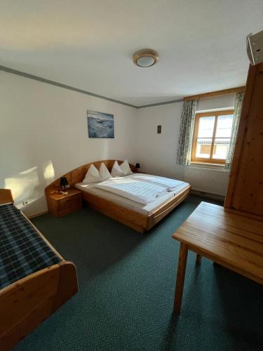 a bedroom with a large wooden bed and a window at Haus Bergblick in Obertauern