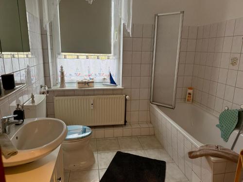 a bathroom with a sink and a tub and a toilet at Ferienwohnung Poschmann in Bad Wilsnack