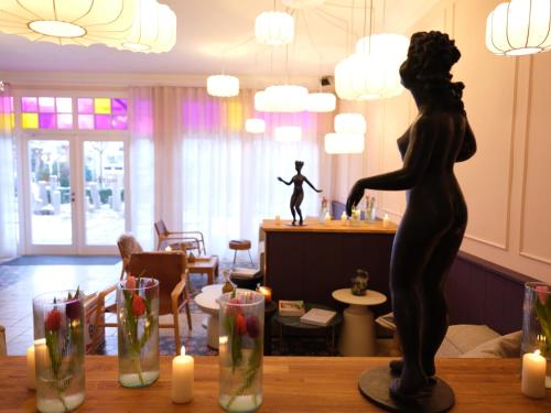 a statue of a woman sitting on a table with candles at freustil Hotel in Binz