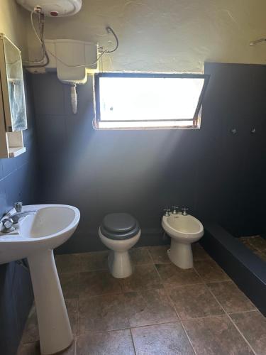 a bathroom with a sink and a toilet and a window at Las Dalias in Tacuarembó