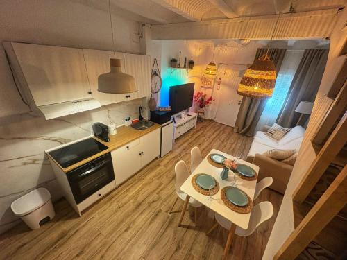 a small kitchen and living room with a table and chairs at Las Casitas de Cullera Sol y Mar in Cullera