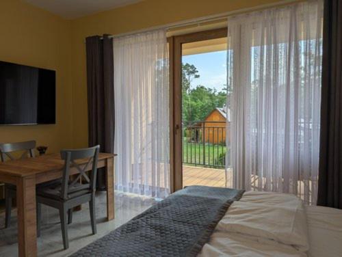 a bedroom with a bed and a desk and a window at Apartamenty Biwakowa 4B in Turawa
