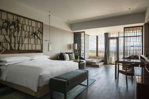 a bedroom with a large white bed and a desk at Beijing Marriott Hotel Changping in Changping
