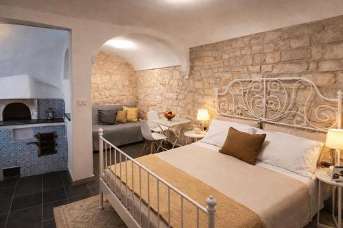 a bedroom with a bed and a living room at Tirella Home in Modica