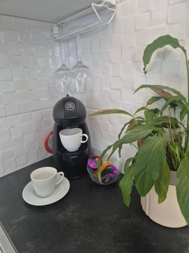 a coffee maker and two cups on a counter at Apartman Srbac in Srbac