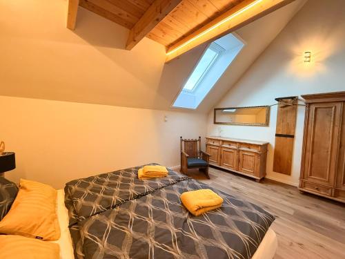 a attic bedroom with a bed and a skylight at Auwer Hills - On dr Schür in Auw