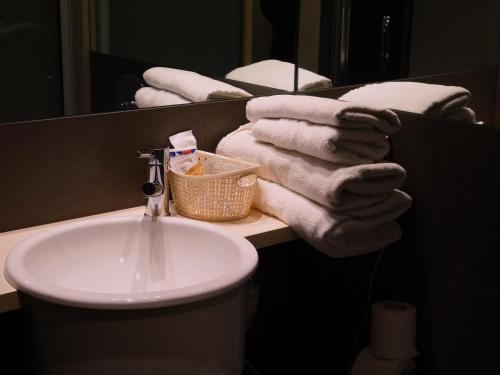 a bathroom with a sink and towels on a counter at Hotel Zarampallo in Ourense