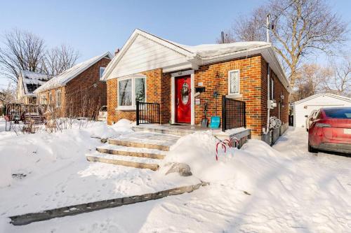 a house with a red door in the snow at The Rustic Barn in Brampton