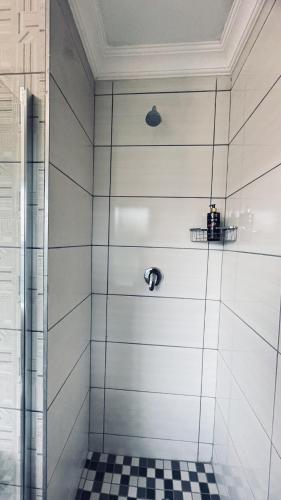 a shower with a black and white checkered floor at Casa Tranquila Luxe in Pretoria