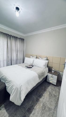 a bedroom with a large bed with white sheets at Casa Tranquila Luxe in Pretoria