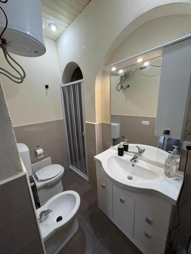 ein Badezimmer mit Waschbecken, Toilette und Spiegel in der Unterkunft Domus Sofia in Ercolano