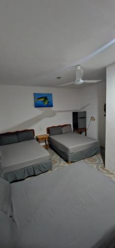 a living room with two beds and a couch at Posada "Las Palmeras" in Dzilam de Bravo