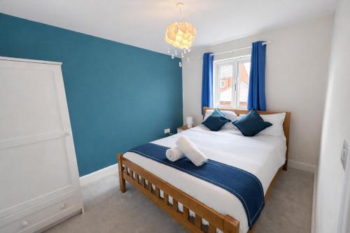 a bedroom with blue walls and a bed with blue pillows at Rudge House in Lichfield