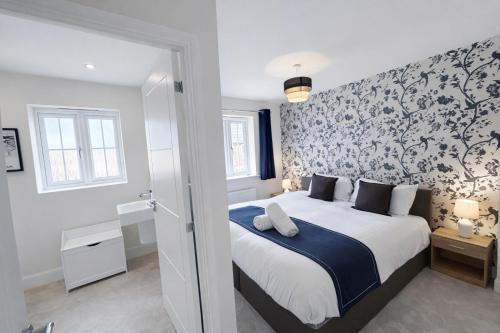 a bedroom with a large bed with a blue blanket at Rudge House in Lichfield