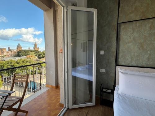 a bedroom with a balcony with a view of the city at Cinquantotto Cozy Rooms in Palermo